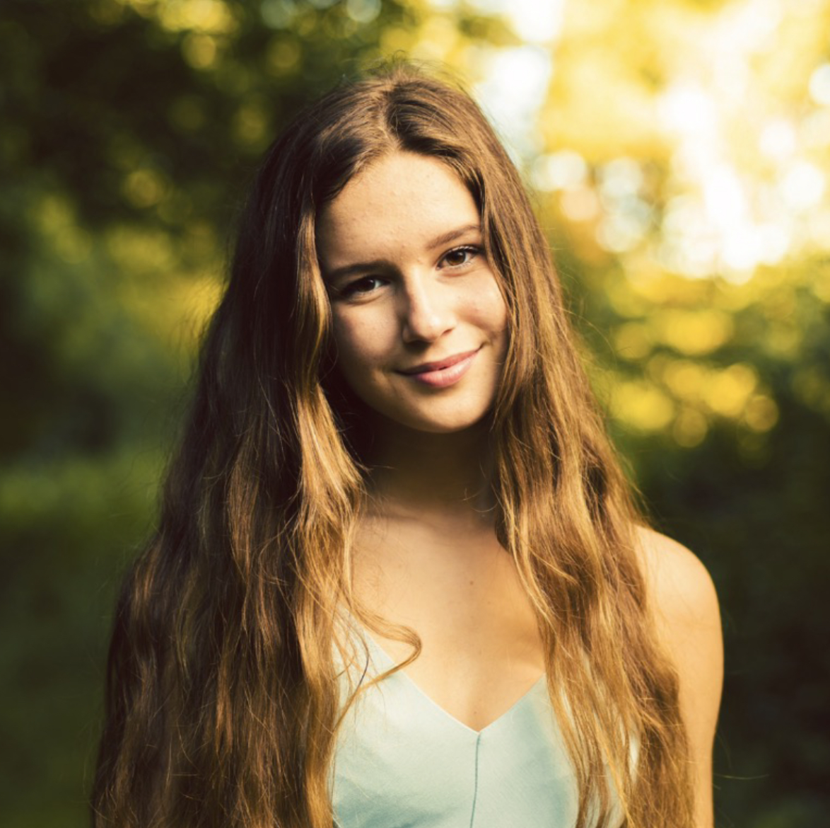 Portrait of young woman with long sandy hair smiling at viewer.